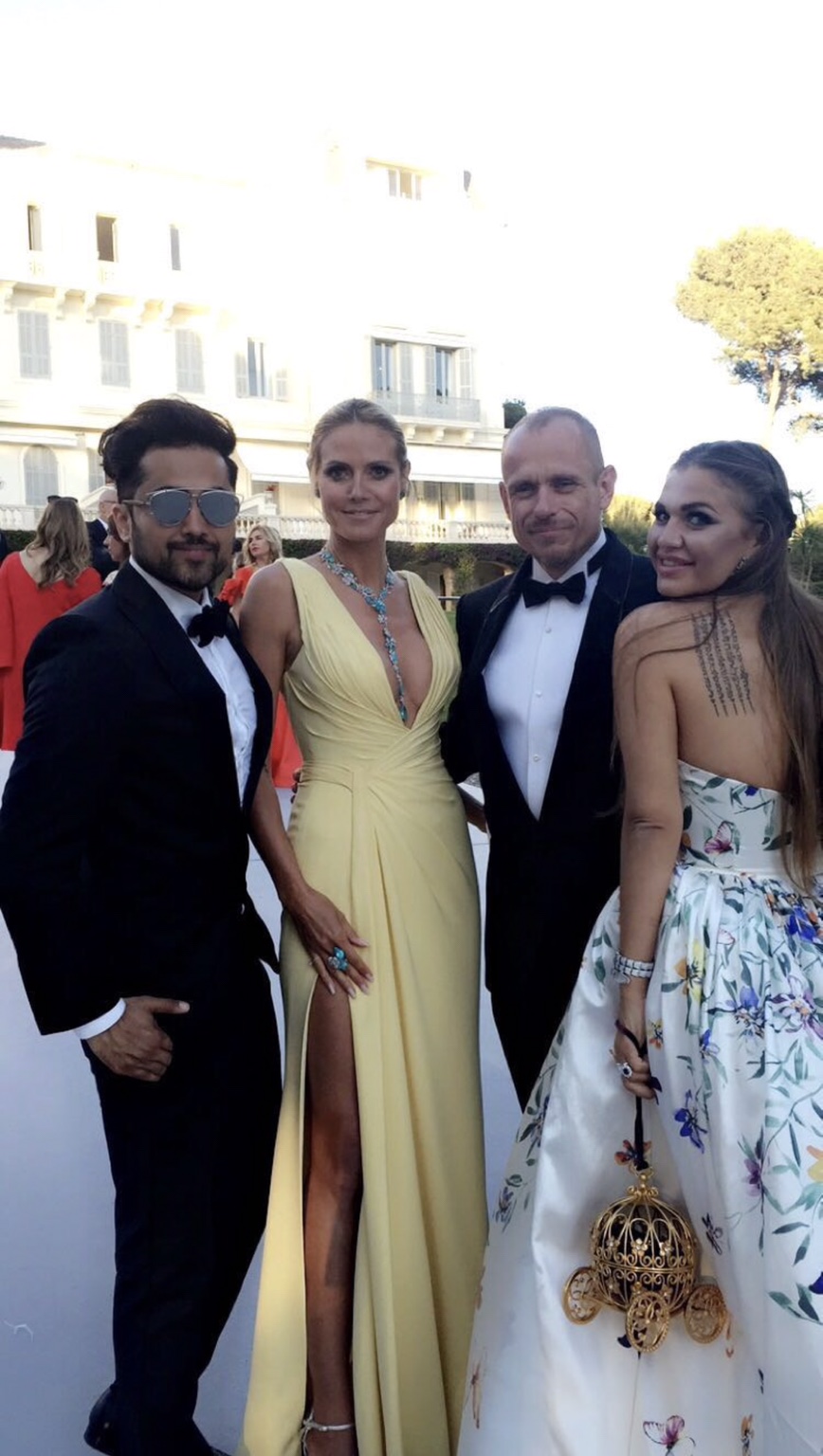 Heidi Klum in einer hellgelben Abendrobe mit tiefem Ausschnitt und hohem Beinschlitz, neben Samuel Sohebi und weiteren Gästen.