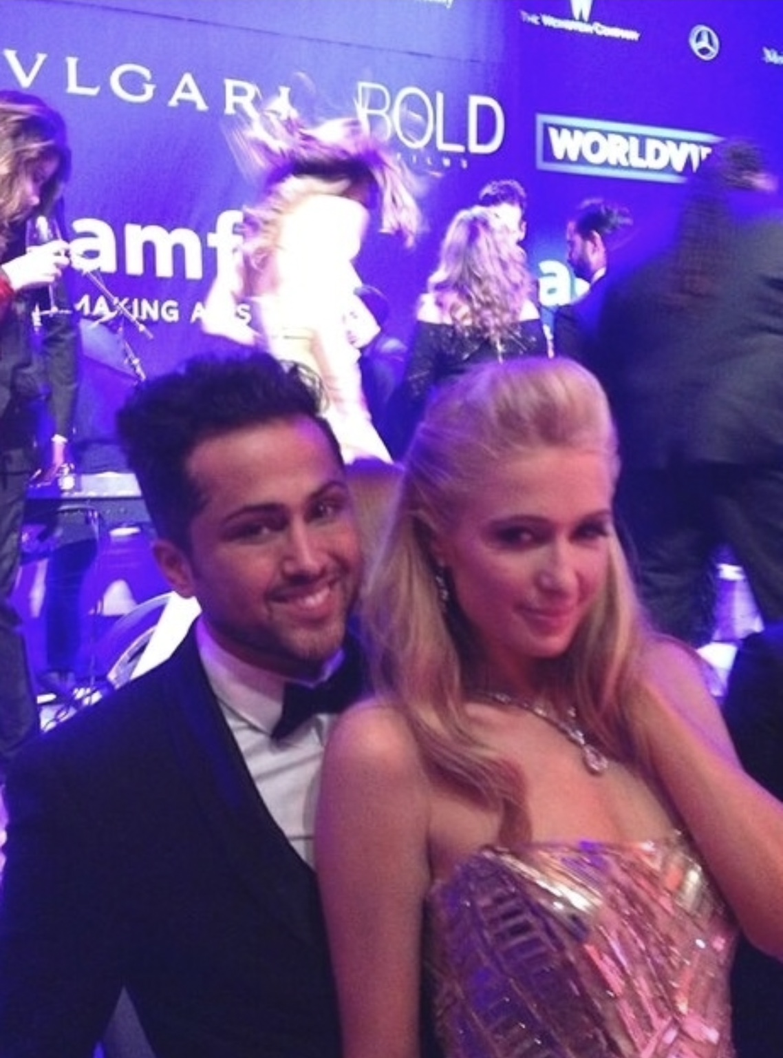 Samuel Sohebi im Smoking bei der amfAR-Gala neben einer Frau in einer roséfarbenen, silberfarben verzierten Abendrobe.