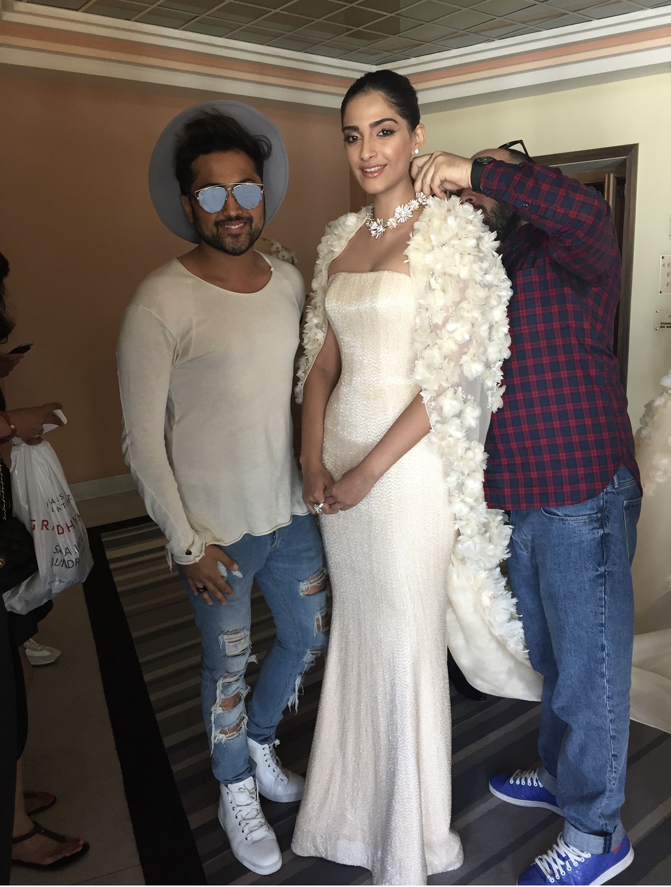 Sonam Kapoor beim Anprobieren einer perlweißen, maßgeschneiderten Ralph-&-Russo-Robe mit floralem Cape; Stylist Samuel Sohebi steht links neben ihr.